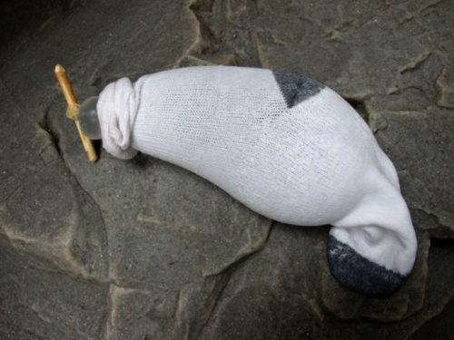préservatif utilisé comme gourde de fortune avec chaussette de protection